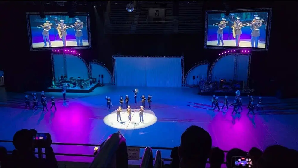 紫色の幻想的なライトアップの中で演奏を披露する、米海兵隊 第3海兵機動展開部隊音楽隊